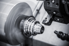 The CNC lathe machine in metal working process finish cutting the metal cone shape parts  with lighting effect. The hi-technology metal working processing by CNC turning machine .